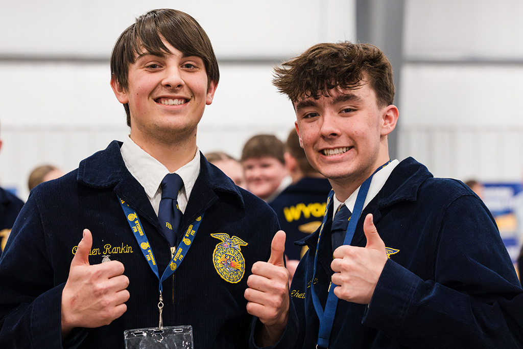 Two high school boys in FFA jackets show two thumbs up gestures